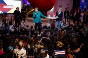 默克爾耐心聆聽兒童提出的各式各樣問題。（圖源：AP）