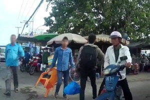 傳統“摩的”司機(藍衣)靠人多勢眾圍攻Grabike 司機。（圖源：視頻截圖）