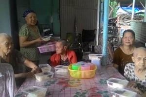 黎氏敬老師向老人們送上晚飯。