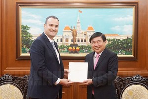 市人委會主席阮成鋒(右)向加拿大駐本市新任總領事凱爾‧努納斯(Kyle Nunas)贈送紀念品。(圖源：市黨部新聞網)