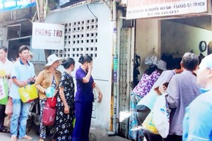 病人家屬排隊等待領取寶和慈善廚房在市腫瘤醫院提供的慈善 餐食。