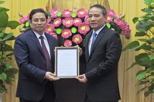 范明政同志（左）向張光義同志授予人事委任《決定》。