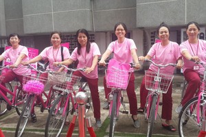 婦女騎自行車宣傳與派發免費檢查券。