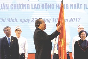 政府副總理張和平在百科大學旗幟 別上一等勞動勳章。 （圖源：越通社）