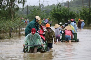為了服務路人，當地民眾已使用牛車拖摩托車過低窪地。（圖源：Tr.Thường）
