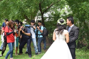 “免費婚照攝影”俱樂部成員們正為一對工人夫妻拍婚紗照。