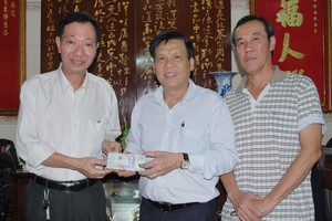 本報主編阮玉英(左二)接受周華邦住持(左一)的贊助金。