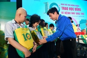 共青團市委常務副書記阮越桂山向癌症病童頒發助學金和贈送禮物。（圖源：光定）