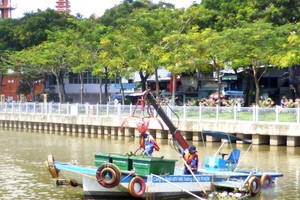 市都市環境公司清潔員採用特製浮船在饒祿-氏藝涌上穿梭打撈水面漂浮物垃圾。