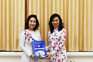 市人委會副主席阮氏秋（右）向原第7軍區文工團副團長阮氏青翠頒發出任文化與體育廳副廳長的《決定》。（圖源：雪阮）