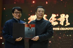 長影集團董事長趙彪(右)為成龍頒發了總導演聘書。（圖源：張瑤）