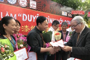 市美協主席黃文梅向越中參展畫家頒發證書。