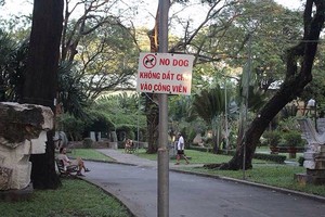 公園周圍當眼處掛上禁止帶狗入公園規定的告示牌，牌上內容用越文及英文書寫，並有插圖說明。