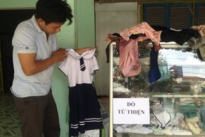 潘青峰整理慈善物品櫃裏的衣服。