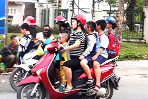 不少家長尚未注重讓孩子坐在摩托車上要戴安全帽。