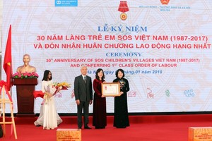 國家副主席鄧氏玉盛代表黨和國家授予越南SOS少兒收容所一等勞動勳章。