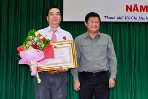 市人委會副主席黃革命(右)向朱杞文同志頒贈三等勞動勳章。