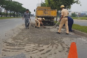執勤交警同民眾用鏟子和掃把積極清理路面的泥土。