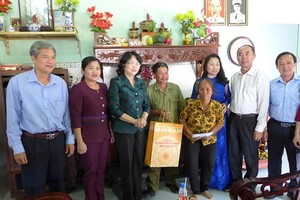 國家副主席鄧氏玉盛(左三)探望並向榮軍家庭阮楊永贈送禮物。
