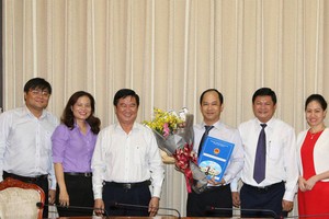 市人委會副主席黃革命向黎德清同志(右三)頒授市人委會主席委任市司法廳副廳長職務的《決定》。（圖源：寶玉）