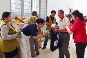 各志願者向貧困老人贈送新年禮物。