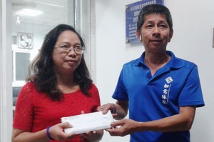 曙光飯店經理（右）將錢包交還失主。