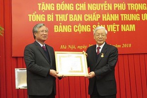 阮富仲總書記(右)榮獲 50 年黨齡紀念章。（圖源：VOV）