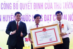 農業與農村發展部副部長陳成南向薄寮省福隆縣領導頒授達新農村標準的《決定》。