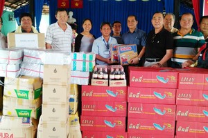 慈善組代表盧榮德（右）向阮文勇副主任移交濟助品。