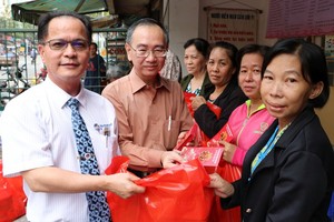 鄭文忠會長和范興主任向第六郡華人送禮。