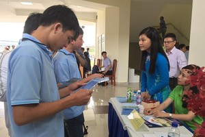 青年在招聘會上尋找工作。