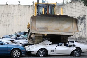 推土機輾碎二十輛走私名車。（圖源：路透社）