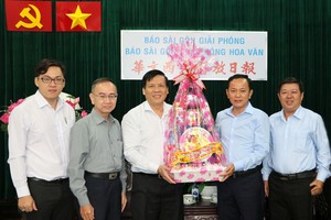 本報主編阮玉英(中)接受代表團的賀禮。