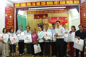 市委民運處主任阮氏麗(左六)贈送春節禮物予第三郡第九坊貧困者。