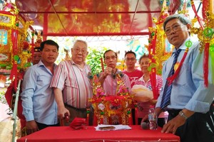 該廟名譽會長梁漢沾(左二)把首盞聖燈交予得主羅楚超先生。