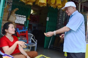 陶春菙與在森德街上的小販聊天。