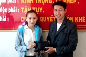 陳武倫(右)把拾到的近9000萬元和隨身證件還給阮氏清心。（圖源：日夏）