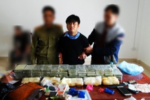 嫌犯楊阿秀(中)與涉案贓物毒品、海洛因及其他物證。（圖源：邊防報）