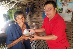 范文勇（右）把善款轉交給需要幫助的人。