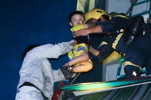 消防員搶救一名兒童離開火警現場。