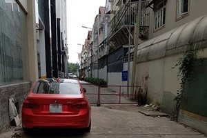 平政縣某舊公寓在路上設圍欄作汽車停車場是違反消防安全規定，此舉將會阻擋消防車進入。