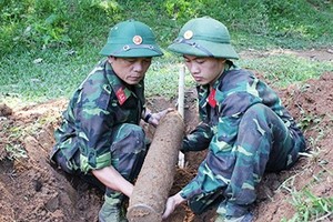 2名工兵將戰後遺留的老炮彈搬移現場。（示意圖源：互聯網）