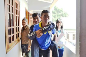 黃文孝在一次的志願活動中背著行動不便的落葉劑受害者。