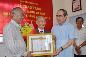 市委書記阮善仁頒授紀念章給黎文毅同志。