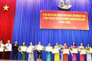 承蒙國家主席的委託，隆安省人委會主席陳文勤向達標的教師頒授“優秀教師”稱號。（圖源：隆安報）