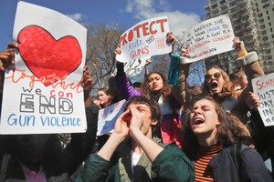 學生持“制止槍械暴力”標語在街上大叫口號。（圖源：AP）