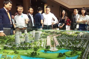 民眾觀看本市某公寓配景圖。