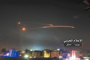 以色列與伊朗近日在敘利亞相互轟炸，以方10日午夜實施大規模空襲，摧毀伊朗在敘的數十個目標。圖為以方飛彈在大馬士革上空畫出2道火線。（圖源：路透社）