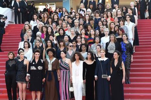 82名女性電影從業者共同身著黑色衣裝，手挽著手分批、排隊走上紅地毯，為性別平等發聲。（圖源：互聯網）