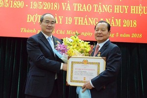 市委書記阮善仁向原黨中央政治局委員、原市委書記黎清海頒授50年黨齡紀念章。（圖源：PLO）